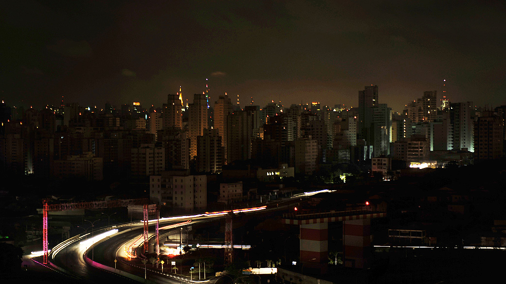 Residential buildings in the Moema neighborhood stand in darkness, the city lit solely by antennas atop buildings and vehicles headlights, during a massive blackout in Sao Paulo, Brazil, early November 11, 2009. A massive blackout across the southern half of Brazil has plunged tens of millions of people into darkness and prompted a major police mobilization amid fears of an opportunistic crime wave. AFP PHOTO/Mauricio LIMA